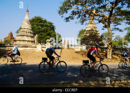 Cyclists on road near Nyaung U, Bagan, Myanmar Stock Photo