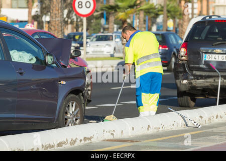 Council worker sweeping glass off road following traffic accident on Gran Canaria, Canary Islands, Spain Stock Photo