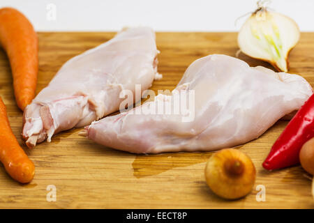 Some pieces of raw rabbit meat with vegetables and spices Stock Photo