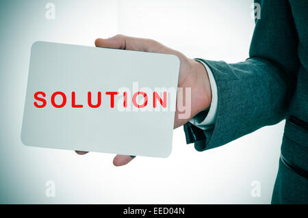a young businessman showing a signboard with the word solution written in it Stock Photo