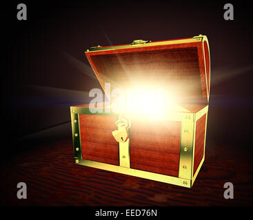 Old wooden treasure chest with strong glow from inside Stock Photo