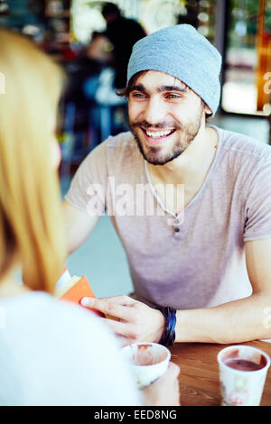 Happy guy looking at his girlfriend while talking to her Stock Photo
