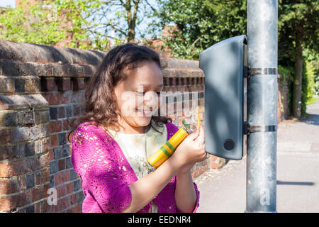 A child taps a key fob onto a 'Beat the Street' box on a lampost to register distance walked. Stock Photo