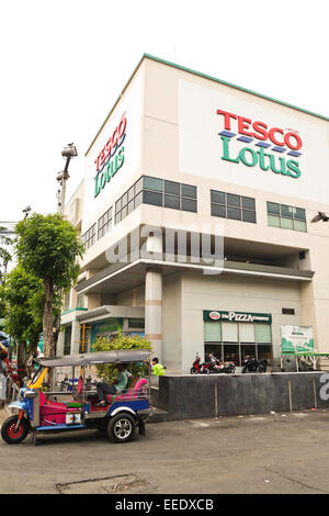 Tesco Lotus facade building a hypermarket chain in Bangkok, tuk tuk in front, Thailand. Southeast Asia. Stock Photo