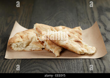 freshly baked georgian pita bread on paper, wood oak table Stock Photo