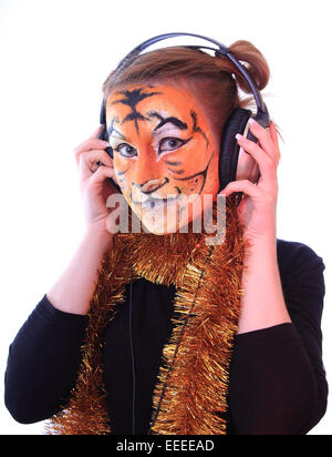 Girl a tiger in headsets listens music. Stock Photo