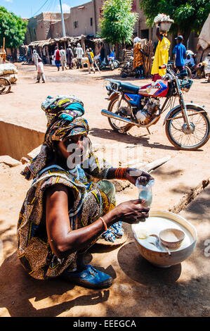 Fulani woman selling milk on the streets of Djenne, Mali. Stock Photo