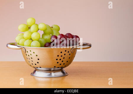 Red and green grapes in a colander Stock Photo