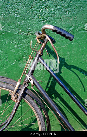 Vintage Bicycle Front end handlebars and green wall Stock Photo