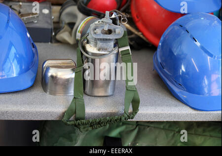 Self-rescuer and hard hats in a display of personal protection equipment used by miners underground Stock Photo