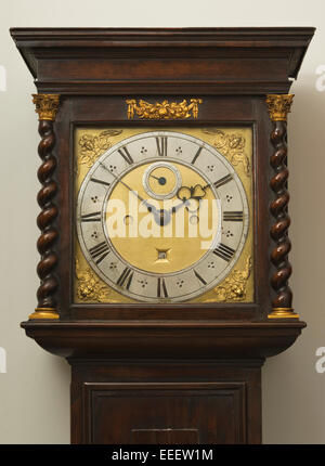 Grandfather/Grandmother clock face, with Roman numerals and twisted wood columns with Corinthian column caps. Long case clock. Stock Photo
