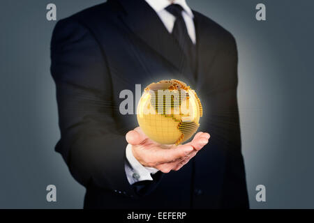 Businessman holding a golden globe Stock Photo