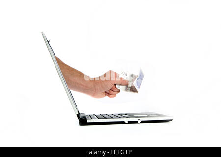 A hand giving a twenty pound not from a laptop as an on-line payment concept. Stock Photo