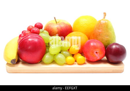 Fresh ripe fruits lying on wooden cutting board, desk of fruits, concept for healthy eating. Isolated on white background Stock Photo