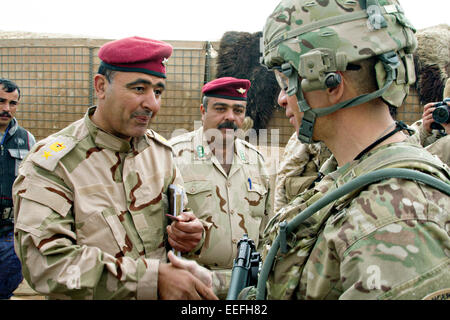 US Army Command Sgt. Maj. Michael A. Grinston an advisor with the 1st Infantry Division, right, greets an Iraqi officer during training of Iraqi army soldiers training at Al Asad Air Base January 15, 2015 in Heet, Iraq. Grinston is helping to develop the training program for Iraqi army battalions in an effort to repel the Islamic State. Stock Photo
