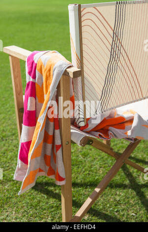 Colourful folding chair and towel by Habitat Stock Photo