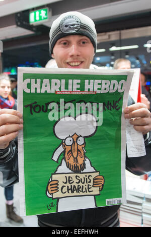 Berlin, Germany. 17th Jan, 2015. Kenny Rebenstock holds a copy of the French satirical magazine 'Charlie Hebdo' in the central station of Berlin, Germany, 17 January 2015. He had waited in front of the bookshop since midnight, to get one of only two copies at 5 in the morning. PHOTO: MAURIZIO GAMBARINI/dpa/Alamy Live News Stock Photo