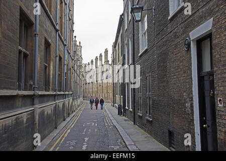 Three young people walk down back street of Cambridge Stock Photo