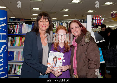 Davina McCall one of Britain's best loved TV Presenters poses with two fans during her book signing at WHSmith in Bromley Stock Photo