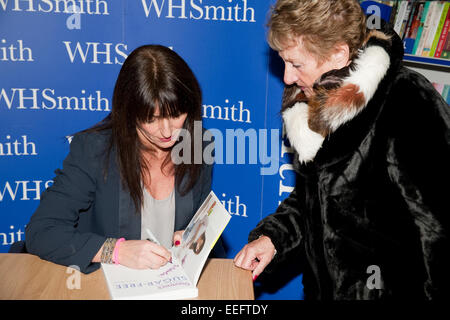 Davina McCall one of Britain's best loved TV Presenters autographs a book for a fan at WHSmith in Bromley Stock Photo