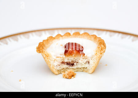 Half Eaten Cherry Bakewell on a plate. Stock Photo