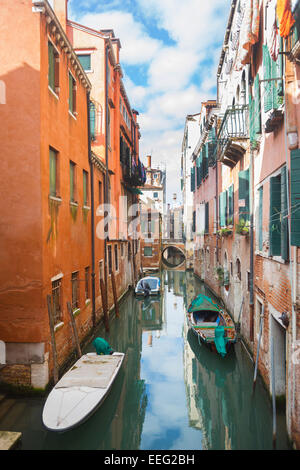 A view of empty boats parked next to buildings in a water canal in Venice, Italy. Stock Photo