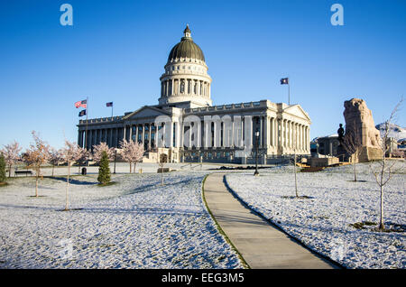 The lawn of the Utah state capitol is covered in a blanket of snow and surrounded by cherry trees. Stock Photo