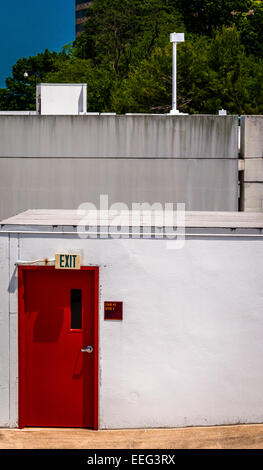 Red door and exit sign on small building in Towson, Maryland. Stock Photo