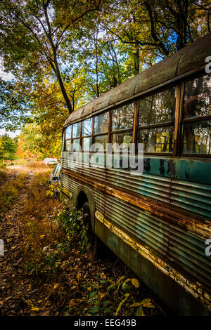 Rusty old school bus in a junkyard. Stock Photo