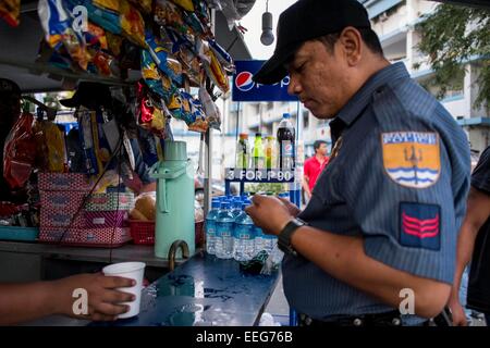 Manila, Philippines, 16th Jan, 2015. A police officer takes his coffee break during the Papal visit. Credit:  Mark Z. Saludes/Pacific Press/Alamy Live News Stock Photo