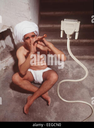 Hamburg, Germany, snake charmer flute playing in front of computer power plug cable Stock Photo