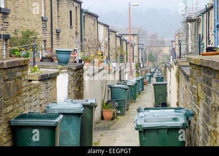 The back alley full of wheelie bins, in the traditional Victorian northern mill town of Saltaire, in Yorkshire, UK. Stock Photo