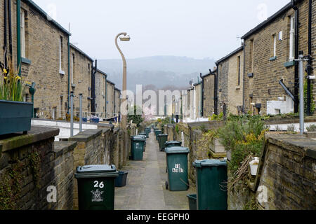 The back alley full of wheelie bins, in the traditional Victorian northern mill town of Saltaire, in Yorkshire, UK. Stock Photo