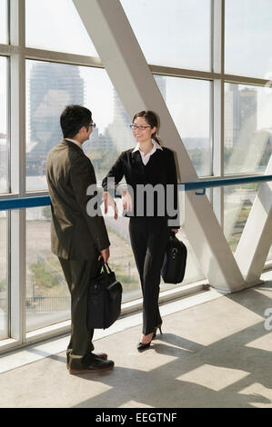 Business couple standing in office building, portrait Stock Photo - Alamy
