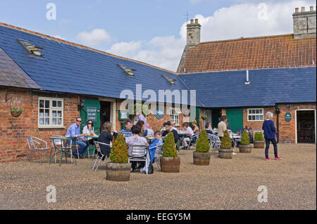 The cafe at Castle Ashby Shopping Yard, customers at outside tables enjoying the warm sunshine. Stock Photo