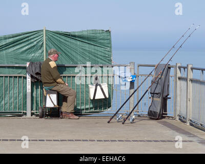 pensioner sea fishing from pier Stock Photo