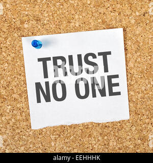 Trust No One Reminder Note Pinned to a Cork Memory Bulletin Board. Stock Photo