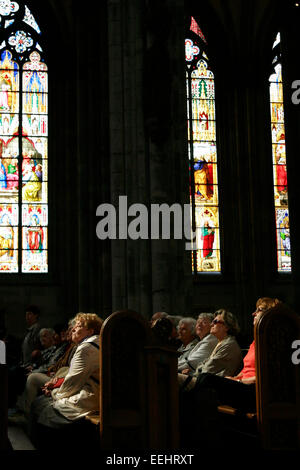 A group of tourists looking at the stained glass windows inside the Cologne Cathedral, Cologne / Köln, Germany Stock Photo