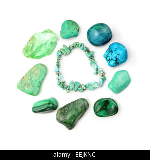 Green and turquoise gemstones in round arrangement, isolated on white background. Turquoise bracelet in centre. Stock Photo