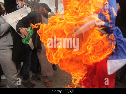 Jan. 19, 2015 - Gaza City, Gaza Strip, Palestinian Territory - Palestinian Salafists burn a French national flag during a protest against the satirical French weekly magazine Charlie Hebdo's cartoons of the Prophet Mohammad, in Gaza city January 19, 2015. Dozens of Jihadist Salafi men rallied in Gaza on Monday to condemn continued publication by French satirical magazine Charlie Hebdo of cartoons deemed offensive to Islam's Prophet. Charlie Hebdo published a picture of Mohammad weeping on its cover last week after gunmen stormed its offices in Paris, killing 12 people. The gunmen said the atta Stock Photo