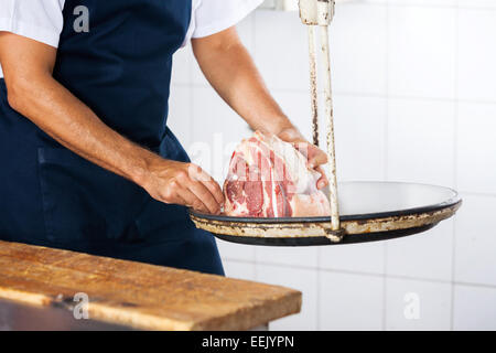 Midsection Of Butcher Weighing Meat Stock Photo