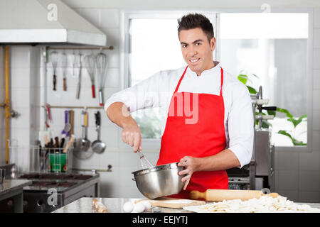 Confident Chef Using Eggbeater To Prepare Ravioli Pasta Stock Photo