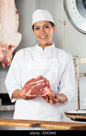 Confident Female Butcher Holding Red Meat Stock Photo