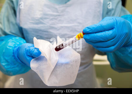 Ebola pathology blood specimen being held by health care worker in protective clothing Stock Photo