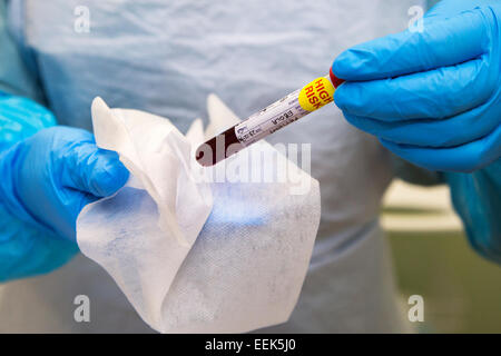 Ebola pathology blood specimen being held by health care worker in protective clothing Stock Photo