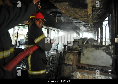 Dhaka, Bangladesh. 19th Jan, 2015. Bangladeshi firefighters extinguish a smoldering vehicles set on fire by opposition demonstrators during violent protests in Dhaka on the 14th day of the countrywide non-stop blockade program enforced by the Bangladesh Nationalist Party-led 20-party alliance on January 19, 2015. Credit:  Mamunur Rashid/Alamy Live News Stock Photo