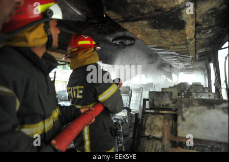 Dhaka, Bangladesh. 19th Jan, 2015. Bangladeshi firefighters extinguish a smoldering vehicles set on fire by opposition demonstrators during violent protests in Dhaka on the 14th day of the countrywide non-stop blockade program enforced by the Bangladesh Nationalist Party-led 20-party alliance on January 19, 2015. Credit:  Mamunur Rashid/Alamy Live News Stock Photo