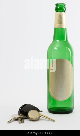 empty beer bottle with car key and crown cork isolated in grey background. Stock Photo