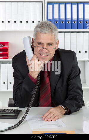 Mann mittleren Alters sitzt im Büro, Middle-aged man sitting in his office
