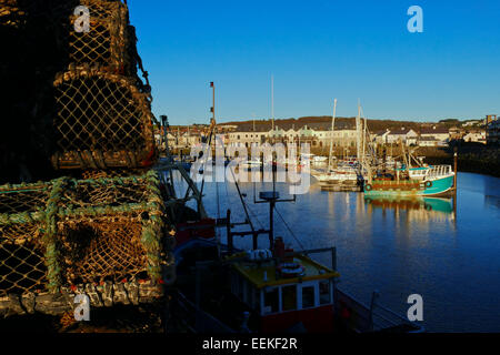 View across Aberystwyth harbour showing fishing boats with lobster pots in the foreground. Stock Photo